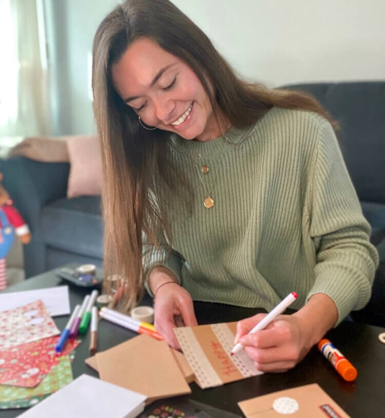 A girl writing on a holiday card.